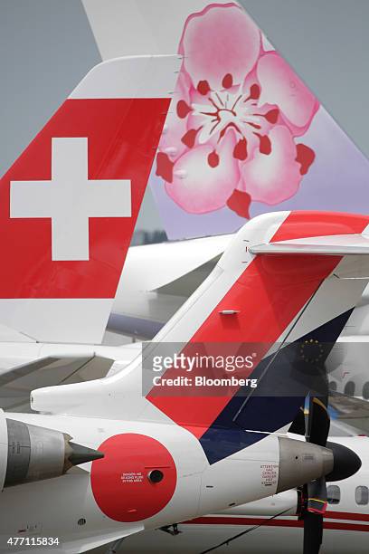 The logos of Swissair AG, left, and China Airlines Ltd., top, sit on the tail fins of aircraft on static display during preparations for the 51st...