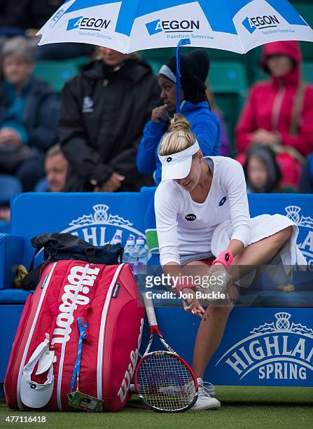 Alison Riske of USA cleans the soles of her shoes during suspended play on day seven of the WTA Aegon Open Nottingham at Nottingham Tennis Centre on...
