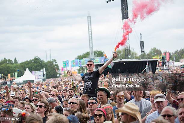 Music fan holds a smoke flare in the middle of the crowd on Day 4 of the Isle of Wight Festival at Seaclose Park on June 14, 2015 in Newport, Isle of...