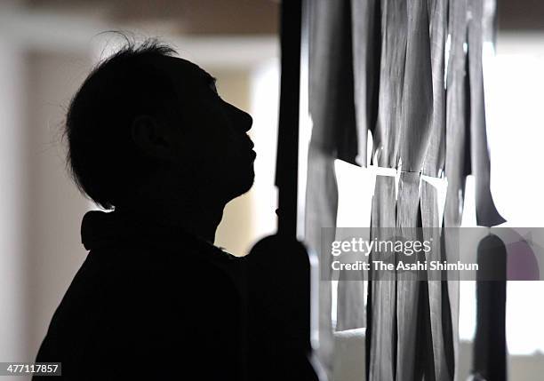 Man looks up the evacuees list put on the wall after a 9.0 magnitude strong earthquake and subsequent tsunami struck at an evacuation center on March...