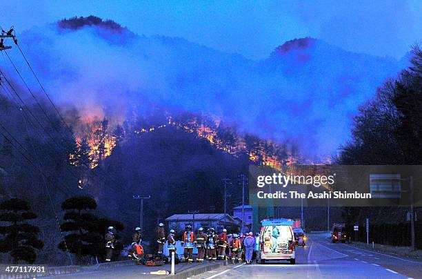 Fire fighters only look up the mountain fire expanding after a 9.0 magnitude strong earthquake and subsequent tsunami struck on March 13, 2011 in...