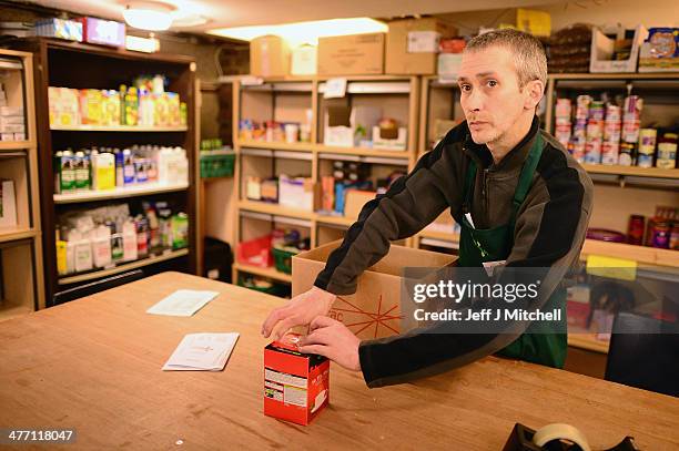 Stuart Little volunteer packs food at a food bank on March 7, 2014 in Whitburn, Scotland. Charities based in Scotland are reporting that many...