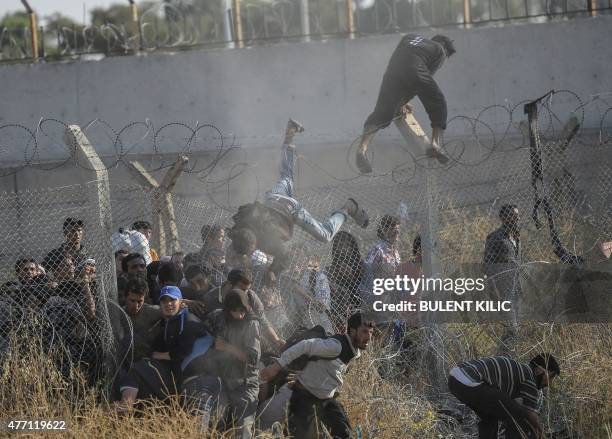Syrians fleeing the war cross broken border fences to enter Turkish territory illegally, near the Turkish border crossing at Akcakale in Sanliurfa...
