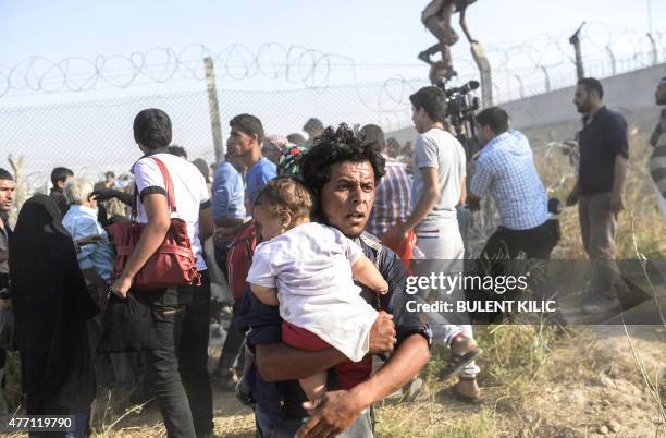 Syrians fleeing the war pass through border fences to enter Turkish territory illegally, near the Turkish border crossing at Akcakale in Sanliurfa...