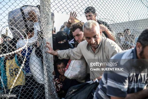Syrians fleeing the war pass through border fences to enter Turkish territory illegally, near the Turkish border crossing at Akcakale in Sanliurfa...