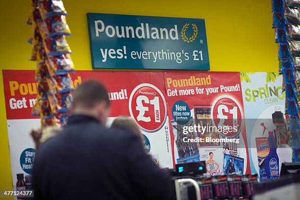 Logo sits on a sign above a check-out desk inside a Poundland discount store, operated by Poundland Group Plc in London, U.K., on Friday, March 7,...