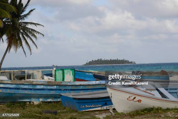 Fishermen's boats lie next to a palm tree on the beachfront against the Johnny Cay coral islet on January 24, 2014 in San Andres, Colombia. Colombia...