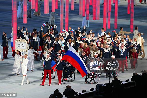 Russia enter the arena lead by flag bearer Valerii Redkozubov during the Opening Ceremony of the Sochi 2014 Paralympic Winter Games at Fisht Olympic...