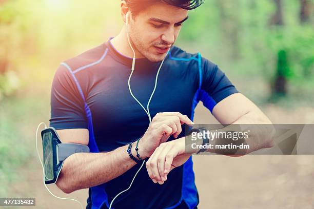 runner in the park using smart watch - checking sports stock pictures, royalty-free photos & images