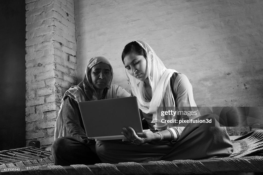 Mother and Daughter Holding Laptop at Home