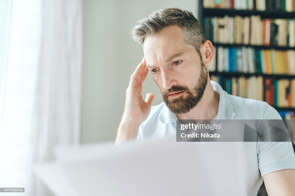 Man with a beard looking over papers