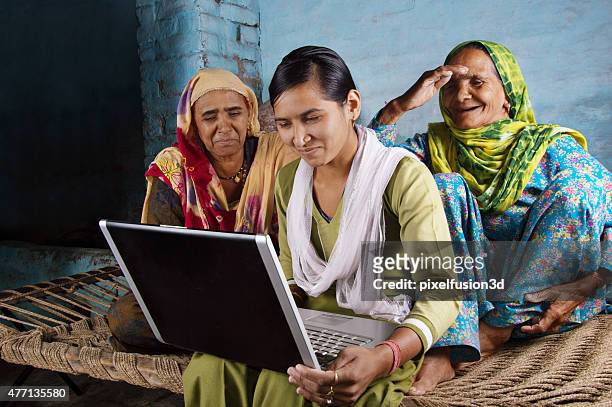 mother and daughter holding laptop at home - social issues stock pictures, royalty-free photos & images