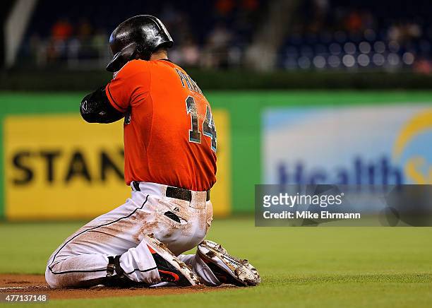 Martin Prado of the Miami Marlins reacts to injuring his shoulder after falling crossing first base during a game against the Colorado Rockies at...