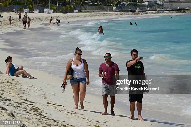 Visitors to the island walk on the sandy beach with their cameras on January 24, 2014 in San Andres, Colombia. Colombia has a territorial dispute...