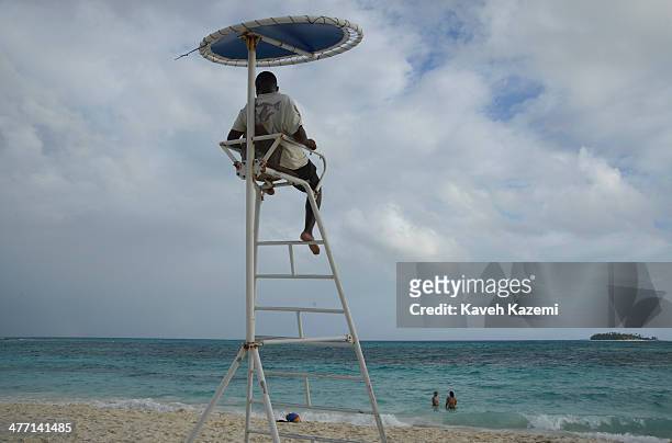 Life guard sits on the watch tower while two women swim in the sea on January 24, 2014 in San Andres, Colombia. Colombia has a territorial dispute...