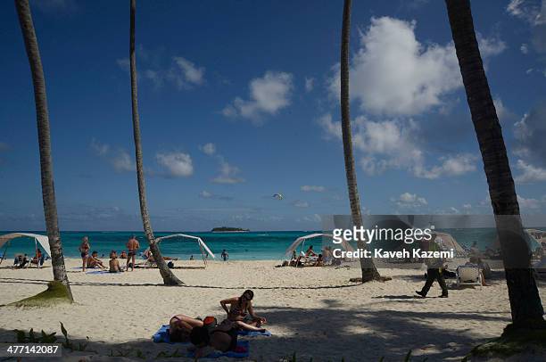 Johnny Cay coral islet is seen in the background of the beach with palm trees where people are spending the day on January 26, 2014 in San Andres,...