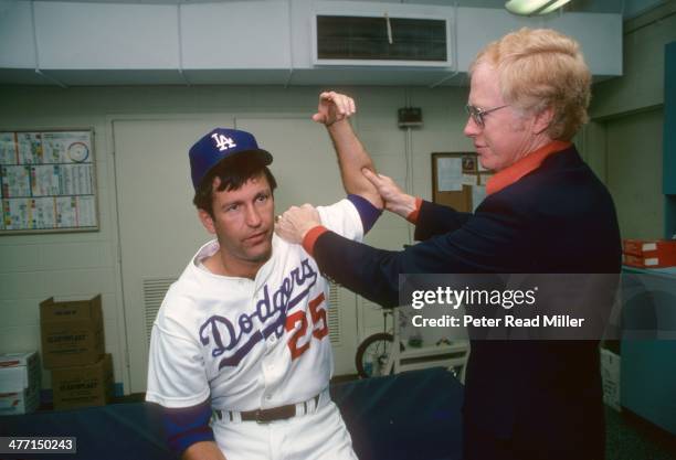 Los Angeles Dodgers orthopedist Dr. Frank Jobe examines the elbow of Tommy John in trainer's room at Dodger Stadium. Dr. Jobe previously replaced the...