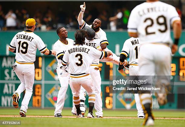 Josh Harrison of the Pittsburgh Pirates celebrates his game-winning RBI single in the 11th inning with teammates Starling Marte, Sean Rodriguez, and...