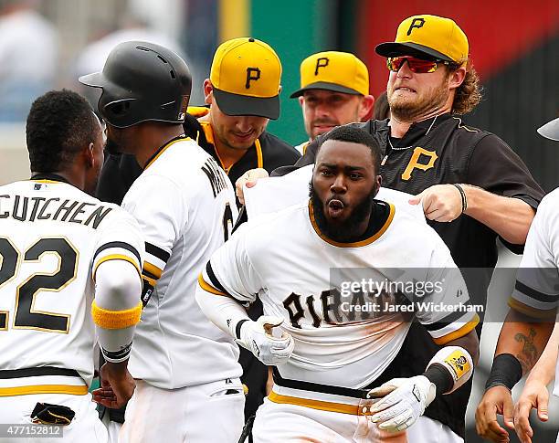 Gerrit Cole of the Pittsburgh Pirates pulls on the jersey of his teammate, Josh Harrison, after Harrison hit the game-winning RBI single in the 11th...