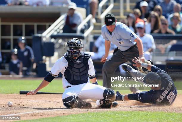 Catcher Jonathan Lucroy of the Milwaukee Brewers is unable to tag out Everth Cabrera of the San Diego Padres as he slides into home plate to score a...