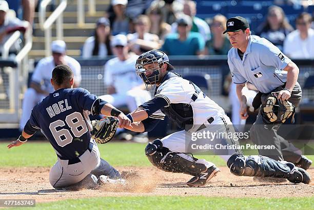 Catcher Jonathan Lucroy of the Milwaukee Brewers is unable to tag out Rico Noel of the San Diego Padres as he slides in to score on an...