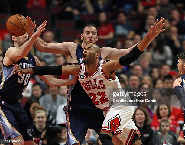 Taj Gibson of the Chicago Bulls is fouled by Kosta Koufos of the Memphis Grizzlies as he moves against Jon Leuer at the United Center on March 7,...