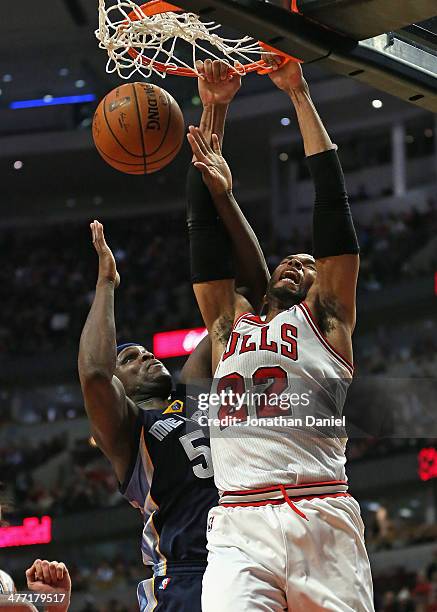 Taj Gibson of the Chicago Bulls dunks over Zach Randolph of the Memphis Grizzlies at the United Center on March 7, 2014 in Chicago, Illinois. The...