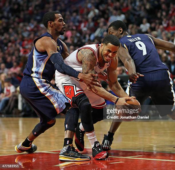 Augustin of the Chicago Bulls fights his way between Mike Conley and Tony Allen of the Memphis Grizzlies at the United Center on March 7, 2014 in...