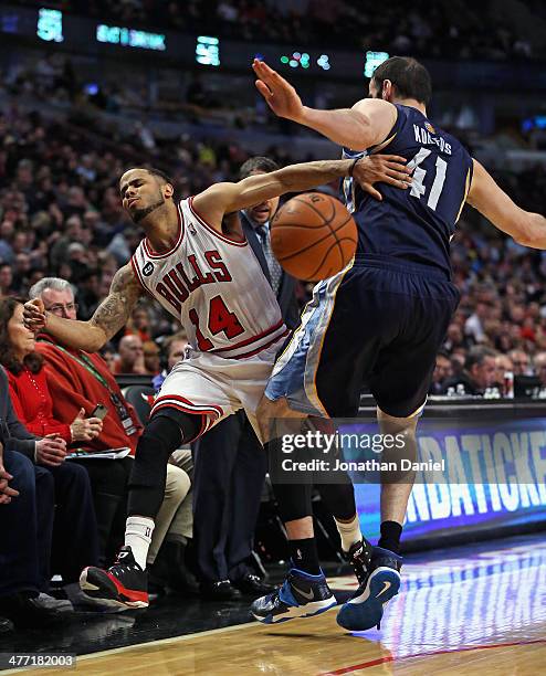 Augustin of the Chicago Bulls is fouled by Kosta Koufos of the Memphis Grizzlies at the United Center on March 7, 2014 in Chicago, Illinois. The...