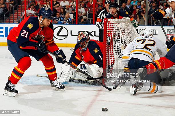 Goalie Roberto Luongo of the Florida Panthers defends the net with the help of teammate Krys Barch against Luke Adam of the Buffalo Sabres at the...