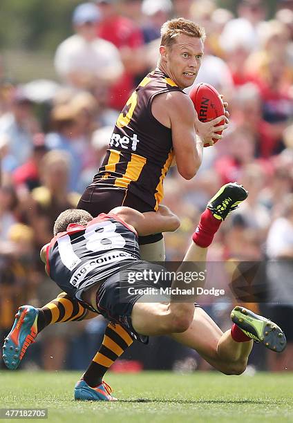 Sam Mitchell of the Hawks looks ahead while being tackled by Daniel Cross of the Demons during the AFL practice match between the Melbourne Demons...