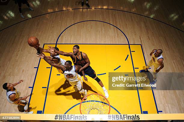 Shaun Livingston and Draymond Green of the Golden State Warriors jump for a rebound against Tristan Thompson of the Cleveland Cavaliers in Game Five...
