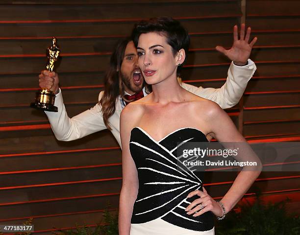 Actor Jared Leto photobombs actress Anne Hathaway at the 2014 Vanity Fair Oscar Party hosted by Graydon Carter on March 2, 2014 in West Hollywood,...