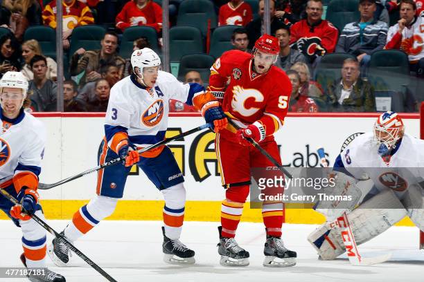 Ben Hanowski of the Calgary Flames skates against Travis Hamonic of the New York Islanders at Scotiabank Saddledome on March 7, 2014 in Calgary,...