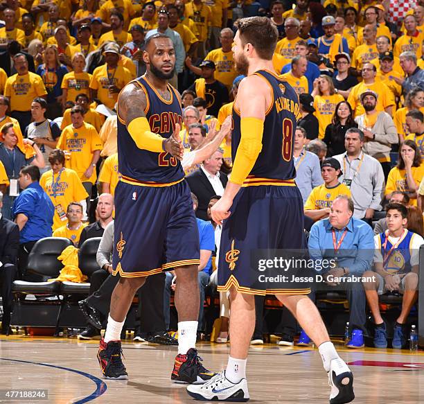 Matthew Dellavedova and Lebron James of the Cleveland Cavaliers shake hands after a play against the Golden State Warriors at the Oracle Arena During...