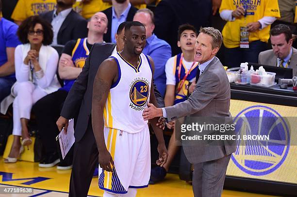 Golden State Warriors coach Steve Kerr gestures to keep Draymond Green from confronting the referee following a call against the Cleveland Cavaliers...
