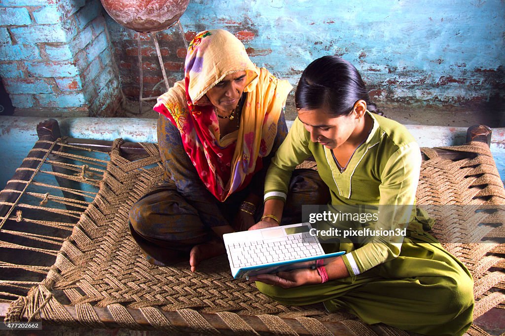 Mother and Daughter Holding Laptop at Home