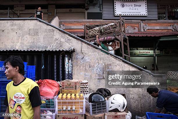 An Indonesian female porter carries tables on her head at Badung traditional market on March 8, 2014 in Denpasar, Bali, Indonesia. Today, around the...