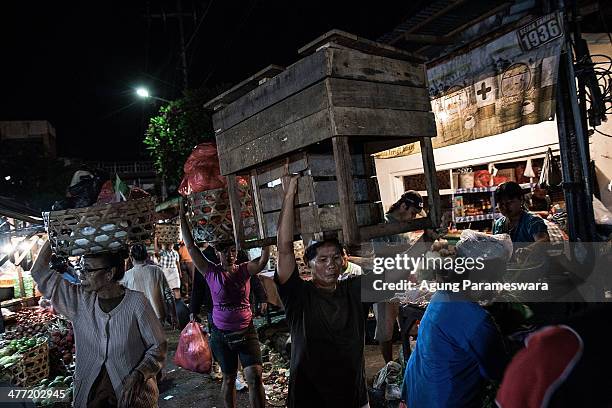 An Indonesian female porter carries a table on her head at Badung traditional market on March 8, 2014 in Denpasar, Bali, Indonesia. Today, around the...