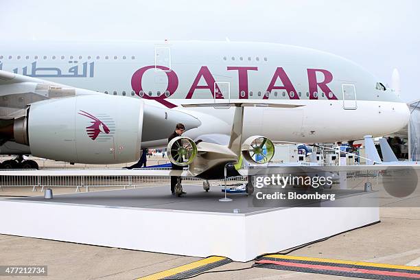 Worker prepares an Airbus SAS E-Fan electric aircraft beside an Airbus A380 airliner, operated by Qatar Airways Ltd., on the opening day of the 51st...