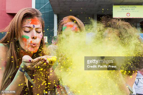 Thousands of people at the second edition of the Turin Holi Fusion, the Festival of Colors of Indian origin. Girls blowing on yellow color.