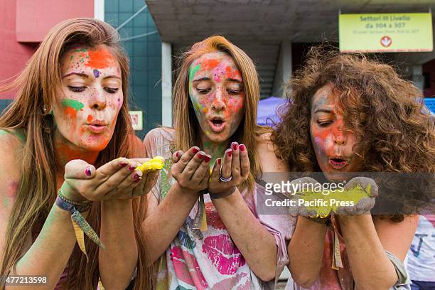 Thousands of people at the second edition of the Turin Holi Fusion, the Festival of Colors of Indian origin. Girls blowing on yellow color.