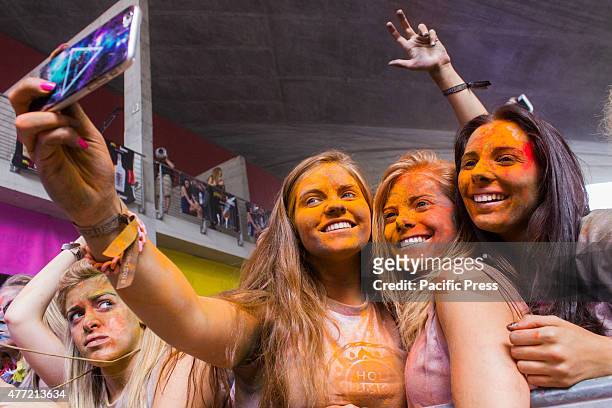 Thousands of people at the second edition of the Turin Holi Fusion, the Festival of Colors of Indian origin. Some girls take a selfie.
