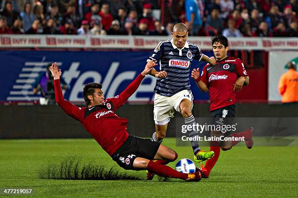 Elio Castro of Xolos and Jorge Enriquez of Chivas compete for the ball during a match between Tijuana and Chivas as part of the 10th round Clausura...