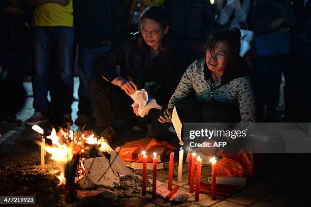 This picture taken on March 7, 2014 shows mourners burning joss money and incenses at the scene of the terror attack at the main train station in...