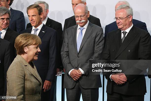 Daimler AG CEO Dieter Zetsche and Volkswagen Group CEO Martin Winterkorn look on as German Chancellor Angela Merkel arrives at the...