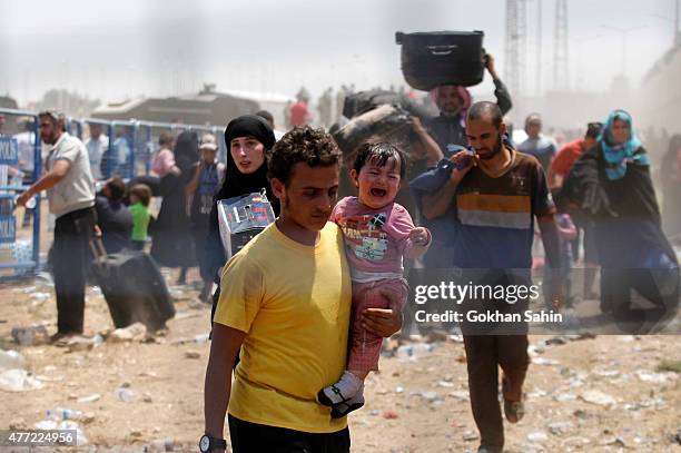 Syrian refugees passing on the Syrian side of the border crossing Akcakale, on June 15, 2015 in Sanliurfa province, southeastern Turkey. Thousands of...