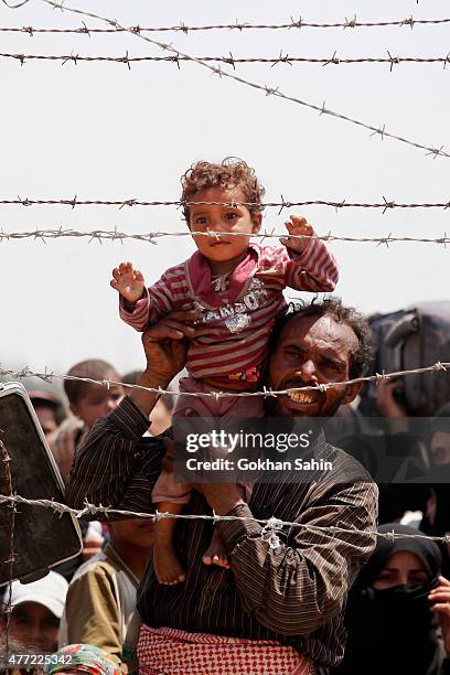 Syrian refugees wait on the Syrian side of the border to cross Akcakale, on June 15, 2015 in Sanliurfa province, southeastern Turkey. Thousands of...