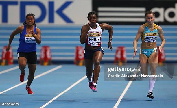 Asha Philip of Great Britain competes with Lovelite Detenamo of Nauru Pacific and Olga Safronova of Kazakhstan compete in the Women's 60m heats...