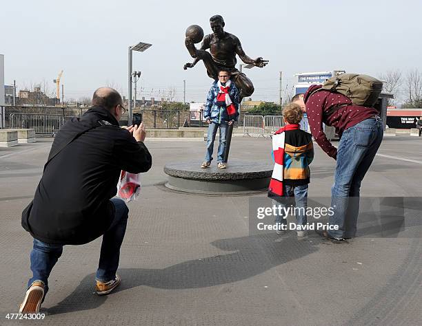 Arsenal fans have their picture taken with the Dennis Bergkamp statue before the FA Cup 6th Round match between Arsenal and Everton at Emirates...